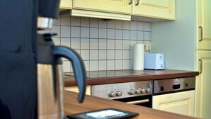 Eine Küche mit Kaffeemaschine, Toaster und Tablet auf der Arbeitsfläche.
