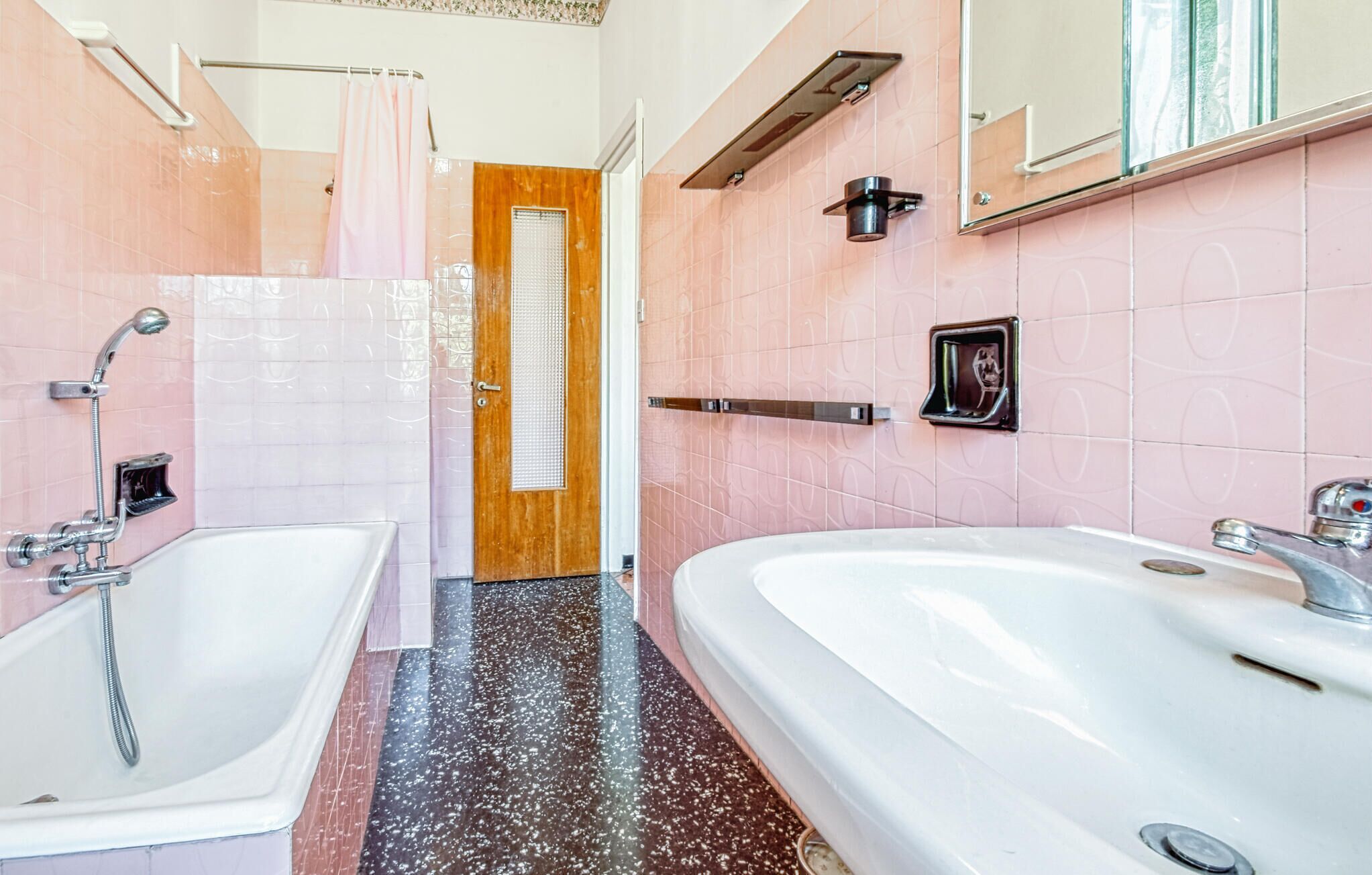 Une salle de bain avec deux lavabos, une douche et un miroir.