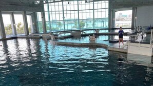 Ein Hallenbad mit freiem Blick auf die Stadt durch große Fenster.