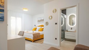 A modern hotel room with a bed, a desk, and a bathroom. - Amazing apartment in Podstrana with WiFi (Podstrana)