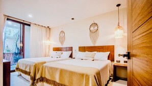 Ein Hotelzimmer mit zwei Betten, einem Balkon und dekorativen Wandbehängen.