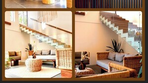 Ein modernes Interieur mit Korbmöbeln, einer Treppe und einem Schild mit der Aufschrift 'AXIA TULU Luxury Lofts'.