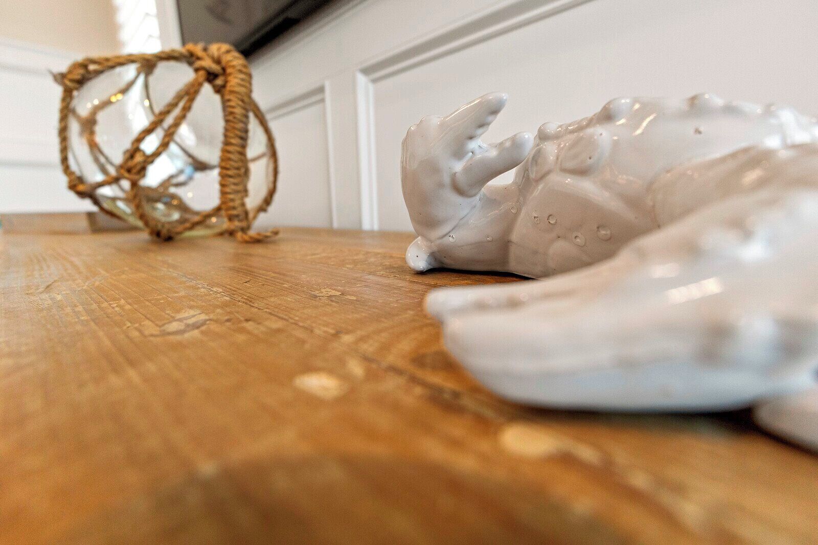 Uma mesa de madeira com uma escultura de cerâmica e uma cesta trançada.