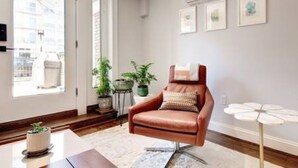 A modern living room with a leather armchair, a coffee table, and a potted plant.