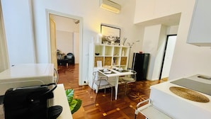 A compact living space with a kitchenette, dining area, and a small seating area. - Apartment Battistero XX Marzo (Parma)