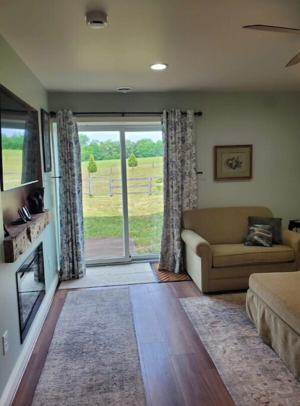 Relax in this stylish living room with a sofa, flat-screen TV, and outdoor access.