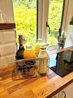 Un comptoir de cuisine avec une bouteille de vin, du jus dâorange et du lait.