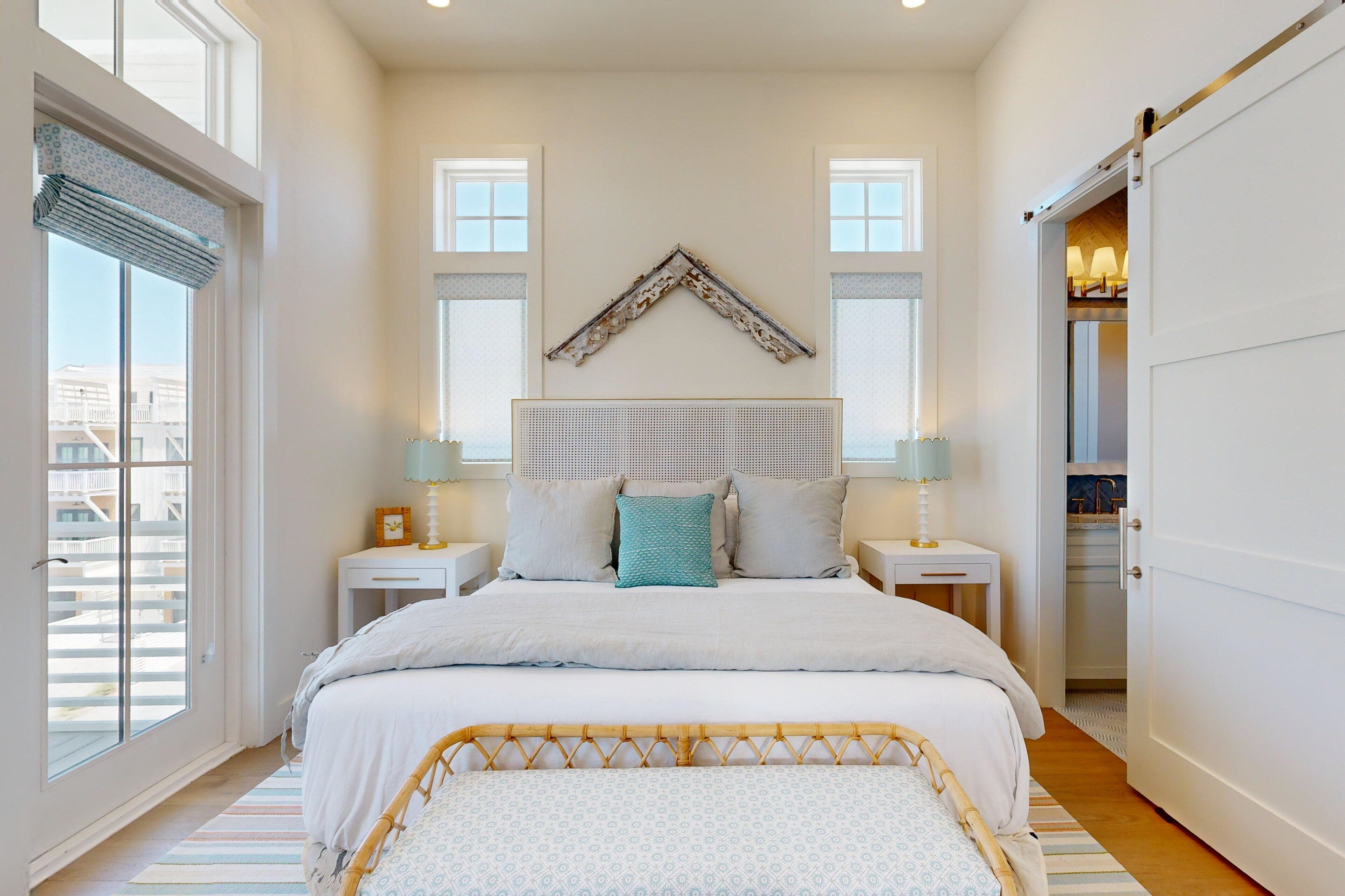 A bedroom with a large bed, two bedside tables with lamps, a decorative wall piece, and a sliding door closet.