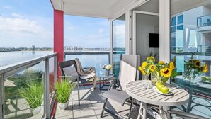 A balcony with a table, chairs, and a vase of sunflowers. - Pet friendly apartment in Olpenitz (Olpenitz)