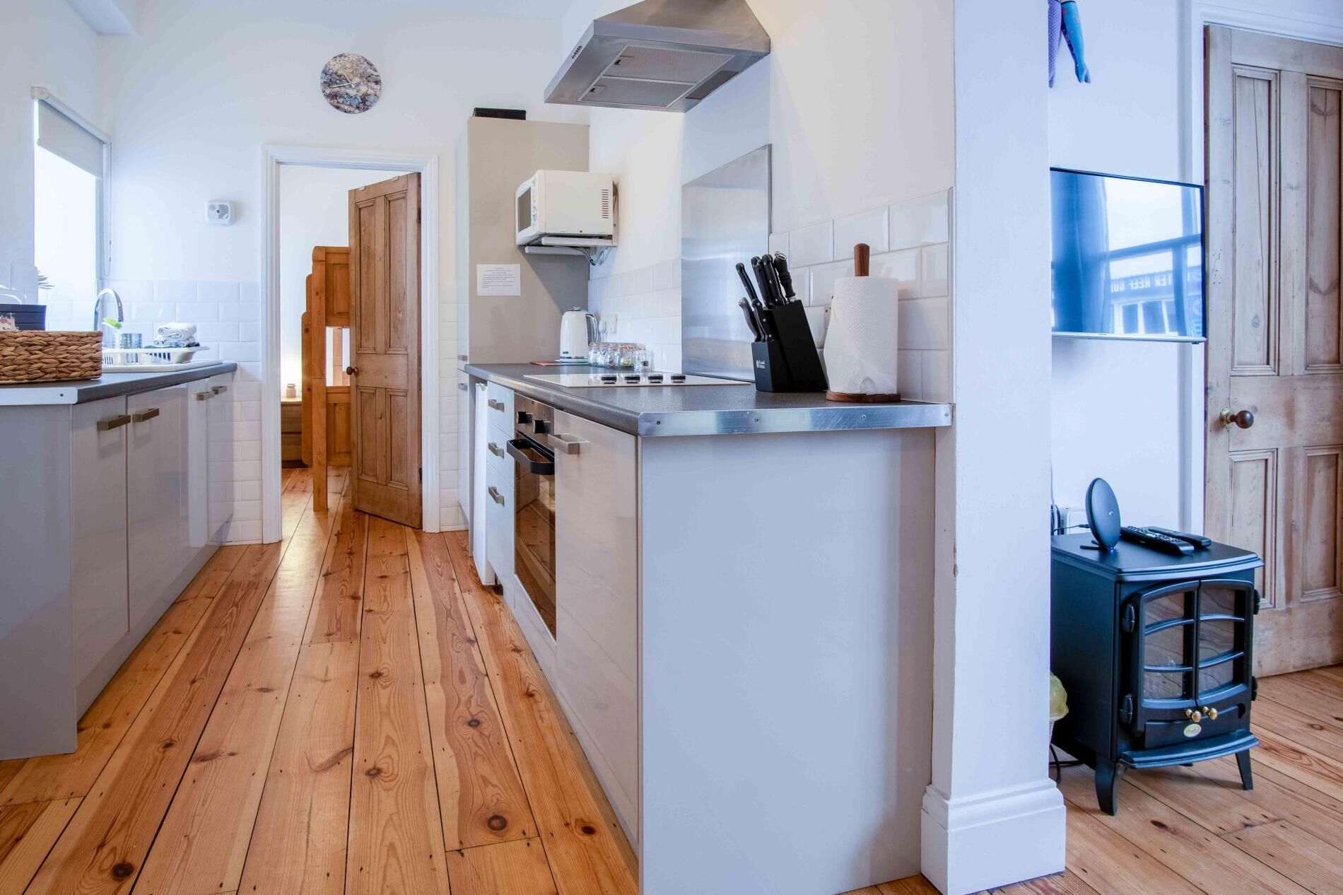 Una cocina moderna con suelo de madera, una isla central y una estufa integrada.