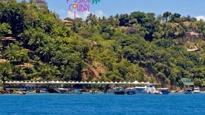 A coastal area with a sign reading "POSADA COLIBRI" and a white tented structure along the shore. - Pousada Colibri (Cairu)