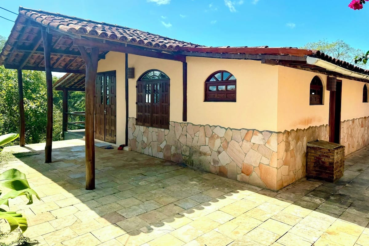 Un bâtiment à deux étages, doté de fondations en pierre, d’un toit en tuiles et d’un patio couvert.