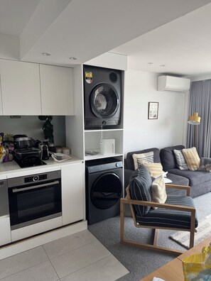 A compact kitchen with a stove, oven, and washing machine.