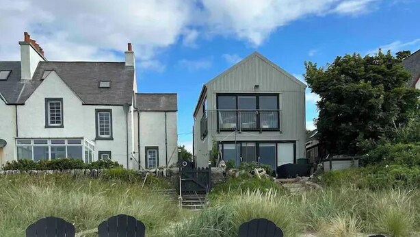 A beach with four Adirondack chairs and a small dog. - Unique house in an idyllic situation on a beach (Port Ellen, Isle of Islay)
