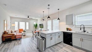 Een moderne keuken met een centraal eiland, roestvrijstalen apparatuur en lichtkleurige kastjes.