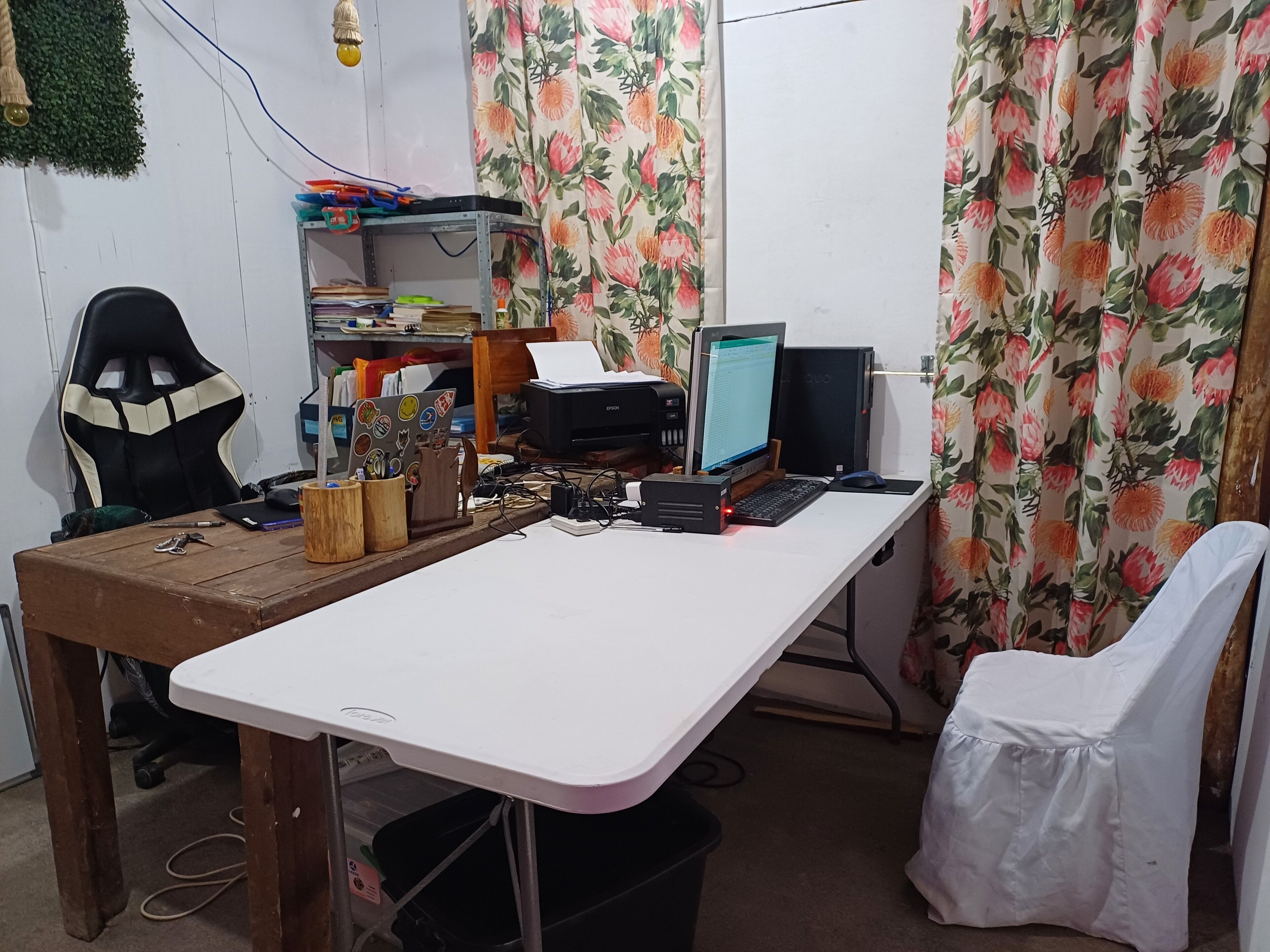 Una postazione di lavoro in casa con scrivania, computer e sedia da ufficio.