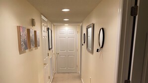 A hallway with beige walls, a carpeted floor, and a white door at the end. - Central Tellico Village Private Apartment, Experience peace & quiet, Non-smoking (Loudon)