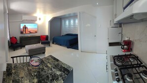Un espacio habitable compacto con cocina, comedor y habitación.