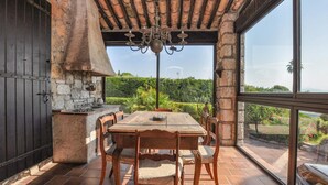 Un comedor con pared de piedra, chimenea y una mesa con sillas.