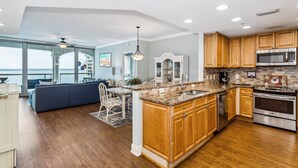 A modern kitchen with wooden cabinets, stainless steel appliances, and a large island.