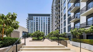 A modern apartment building with a central staircase leading to the entrance. -  Premium Apartments at Executive Residences (Dubai)
