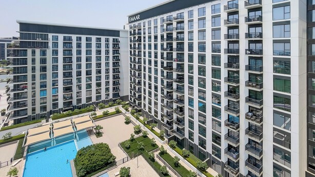 A high-rise residential building with multiple balconies, a swimming pool, and a well-maintained garden area. -  Premium Apartments at Executive Residences (Dubai)
