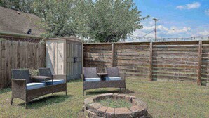 Un espace extérieur aménagé dans un style rustique, avec des meubles en osier et un abri en bois.