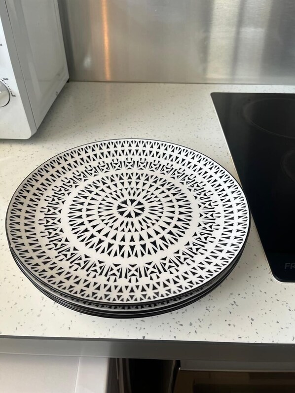 Una encimera de cocina con una placa metálica decorativa que presenta un diseño geométrico.