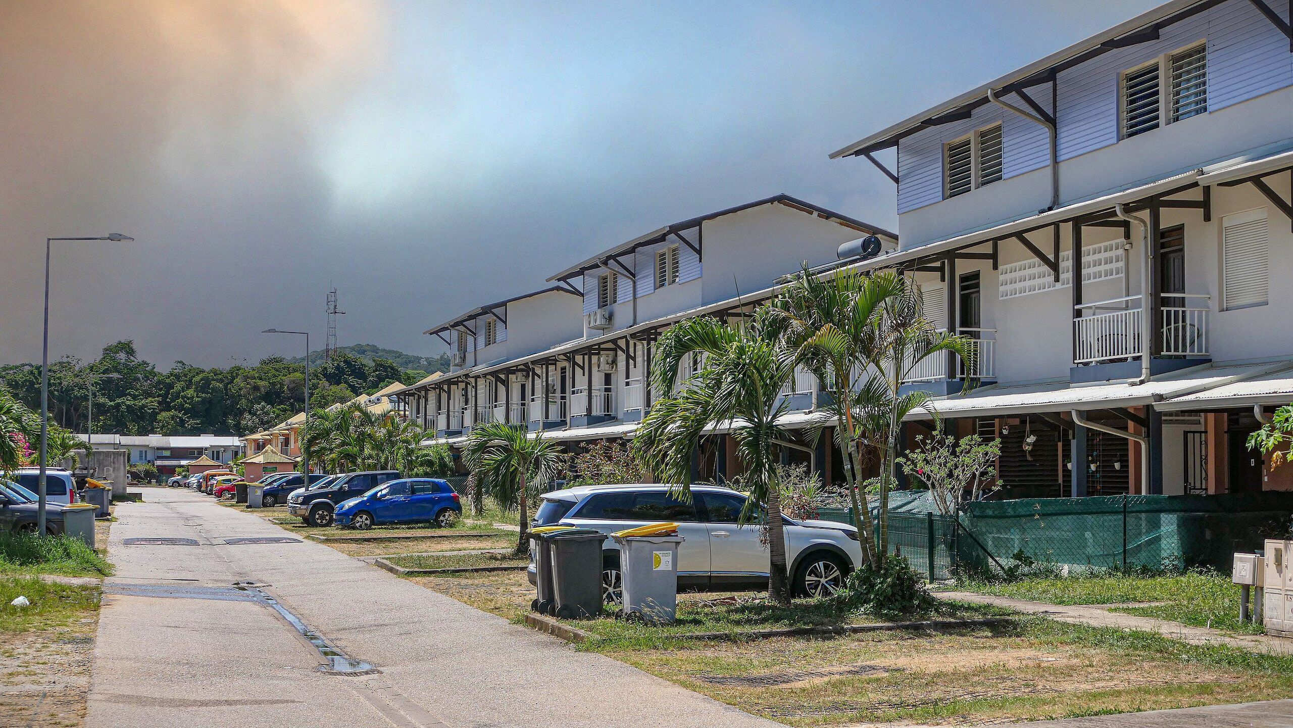 A row of two-story residential buildings with a street in front.