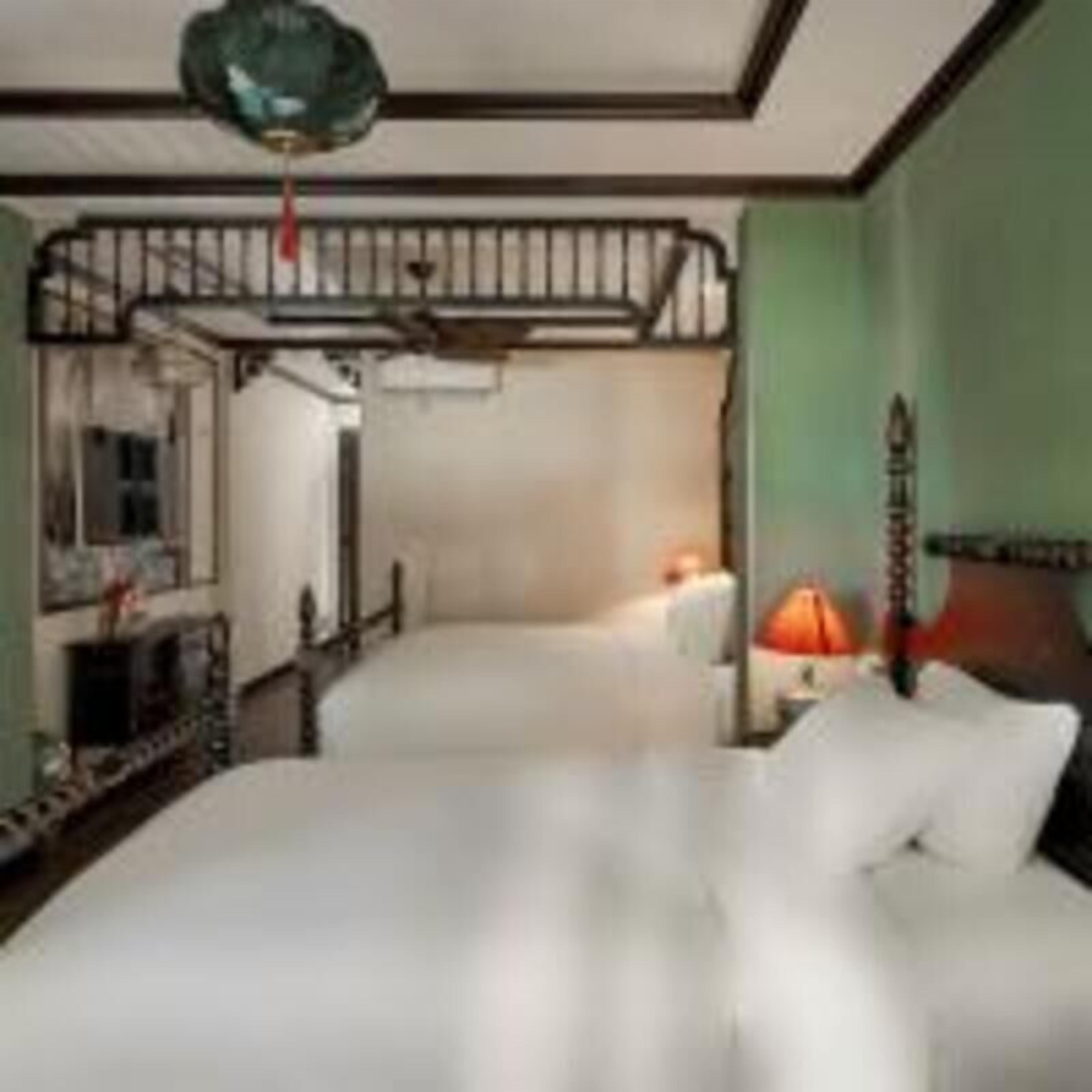 A room with a bunk bed, a desk, a chair, and a lamp.