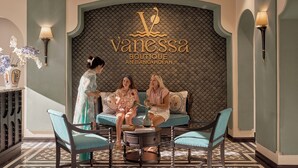 A boutique interior with a patterned wall, a sofa, and two chairs. - Vanessa Boutique Hotel An Bang Beach (Da Nang)