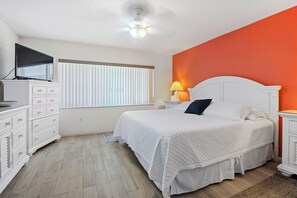 Relax in this stylish bedroom with a large bed, flat-screen TV, and comfortable seating area.