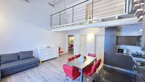 Un appartamento moderno con zona pranzo, cucina e soppalco.