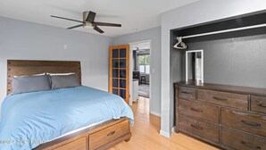A bedroom with a bed, wooden dresser, and a ceiling fan. - "Bright and Stylish Anchorage 2 - Bedroom House - "7 mins from ANC" (Anchorage)
