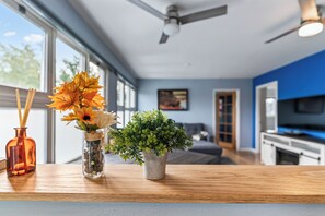 A modern kitchen with a wooden countertop, a ceiling fan, and a view of the living area through large windows. - "Bright and Stylish Anchorage 2 - Bedroom House - "7 mins from ANC" (Anchorage)
