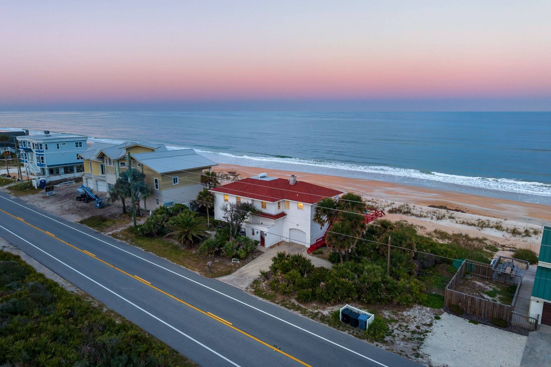 A coastal road with houses and a beach.