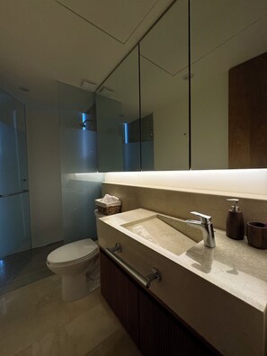 Ein modernes Badezimmer mit großem Spiegel, Waschbecken und Toilette.
