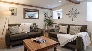 Ein gemütliches Wohnzimmer mit zwei Sofas, einem Couchtisch und einem an der Wand befestigten Kompass.