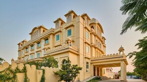 A large, multi-story building with a traditional architectural style, featuring arched windows and decorative elements. - Caelum Atharva Palace  (Jaipur)