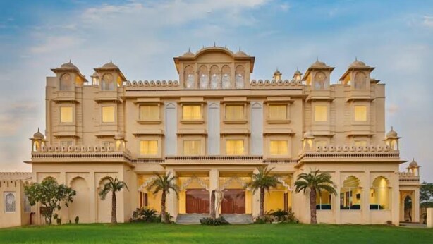 A large, multi-story building with a symmetrical facade, multiple balconies, and a central entrance with steps. - Caelum Atharva Palace  (Jaipur)