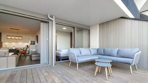 A modern living room with a sectional sofa, a small coffee table, and a dining area with a table and chairs.