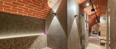 Un espacio de spa con pared de ladrillo, un banco y techo de madera.