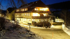 Un hôtel doté d’un balcon, d’une allée enneigée et offrant une vue sur les montagnes.