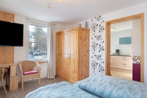 A bedroom with a bed, a desk, a chair, a wardrobe, and a TV. - Apartment 'Ferienwohnung 2 Personen' with Shared Garden, Balcony and Wi-Fi (St. Georgen)