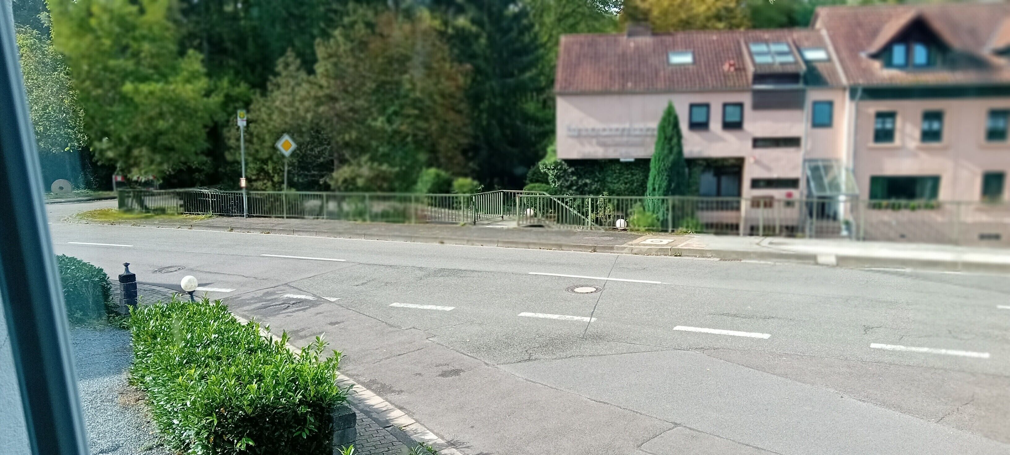 Uma estrada com faixa de pedestres, sinal de trânsito e um edifício com telhado inclinado.