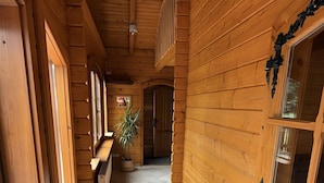 A wooden hallway with a checkered floor, a potted plant, and a door with decorative glass panels. - Holiday Home 'Idylle Ferienhaus Ems' with Lake View, Wi-Fi and Air Conditioning (Walchum)