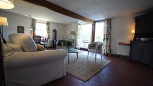 Una sala de estar con un sofá, sillas, una mesa de centro y una chimenea.