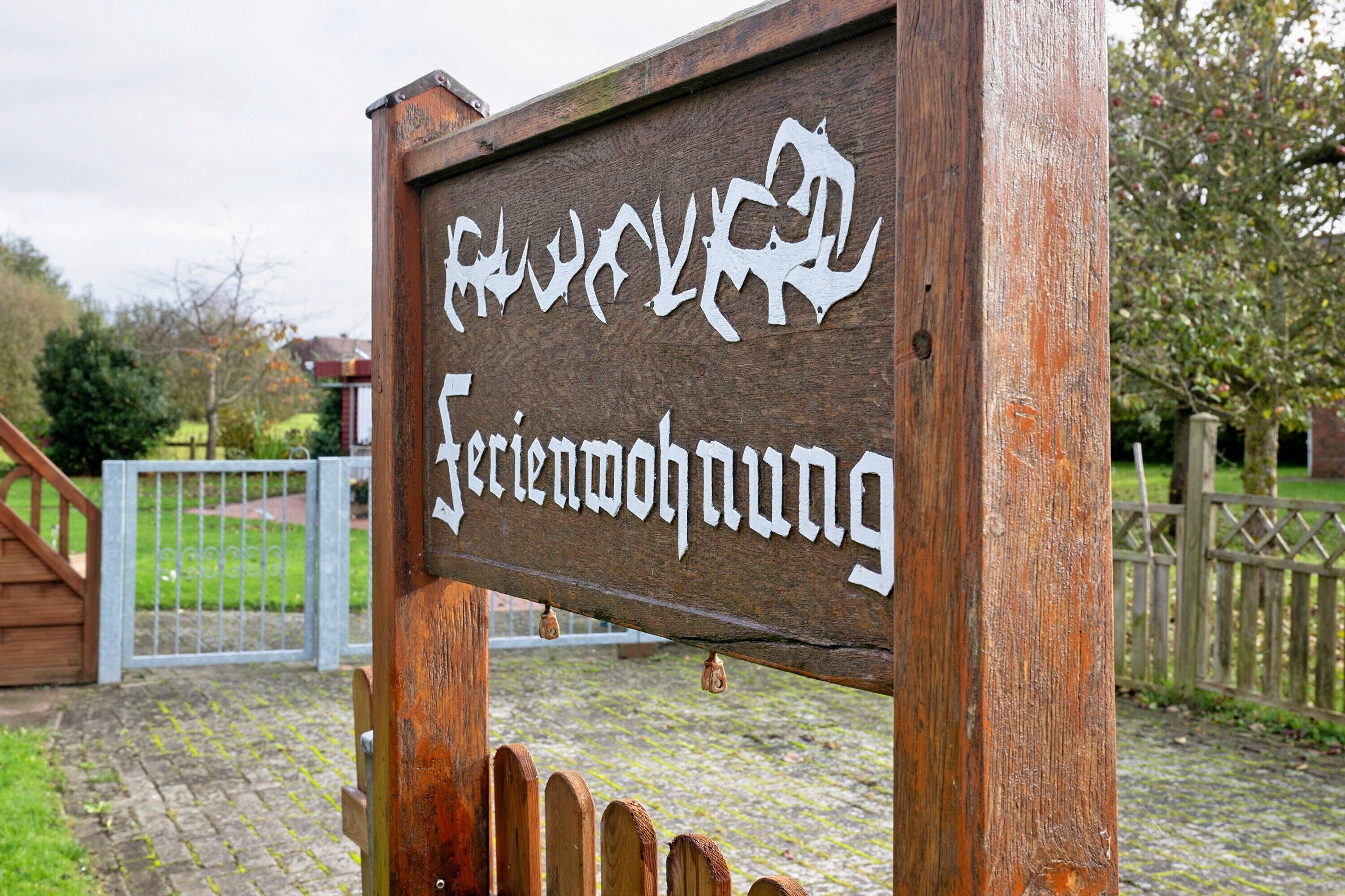 A wooden sign with white lettering, possibly indicating a location or establishment.