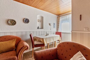 Ein Essbereich mit Tisch, Stühlen und Wanddekorationen.