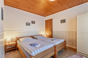 Ein Schlafzimmer mit zwei Holzbett, einem Kleiderschrank und einer Deckenleuchte.